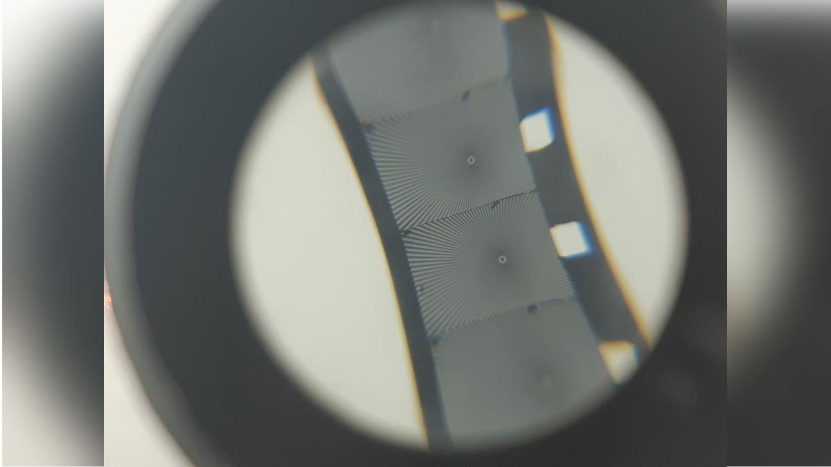 A photograph of a section of film reel as seen through a magnifying glass.