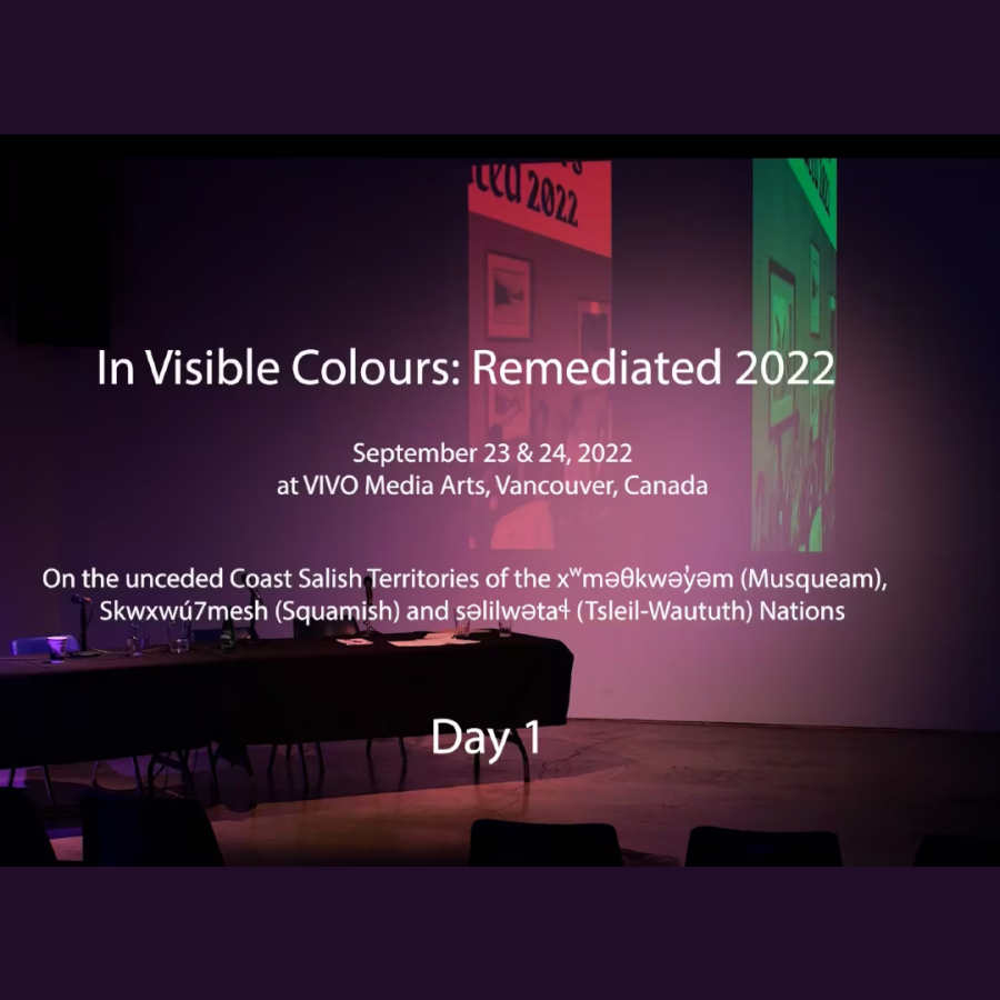 A square image featuring a screenshot of a video of a darkened gallery space with a table in it. Overlayed atop this image is text that says "In Visible Colours: Remediated 2022."