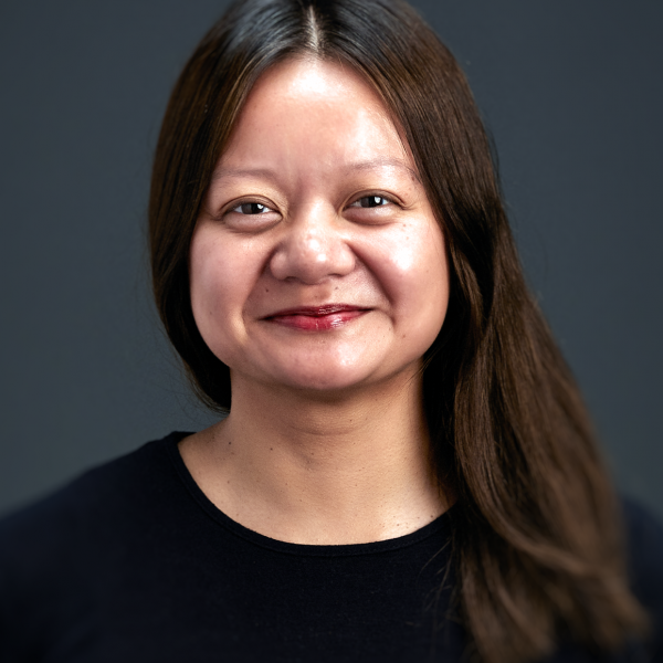 A headshot photo of a dark-haired woman wearing a black shirt.